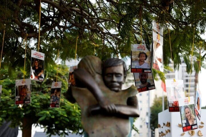 イスラエルのネタニヤフ首相は１８日、パレスチナ自治区ガザにおけるイスラム組織ハマスとの停戦合意を全閣僚による閣議で承認したと発表した。写真は木に吊るされているイスラエルの人質らの写真。１７日撮影（２０２５年　ロイター／/Amir Cohen）