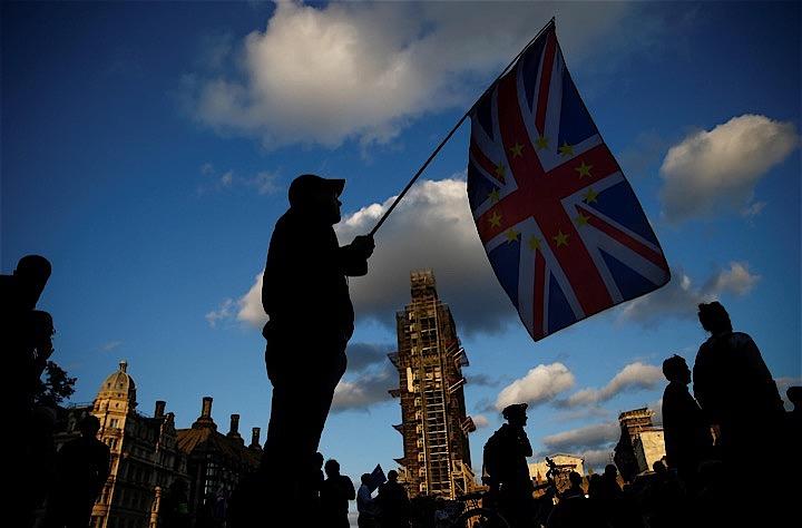 英議会下院は、10月31日に英国を合意なしで欧州連合（EU）から離脱させようとするジョンソン首相の動きを阻止する法案を可決した。写真はロンドンの英議会前で英国旗を掲げる人（2019年　ロイター/Henry Nicholls）