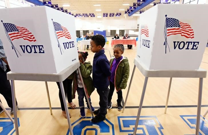 １１月８日、米ノースカロライナ州の投票所で総選挙に投票する母親を見守る子どもたち（２０１６年　ロイター/Jonathan Drake）