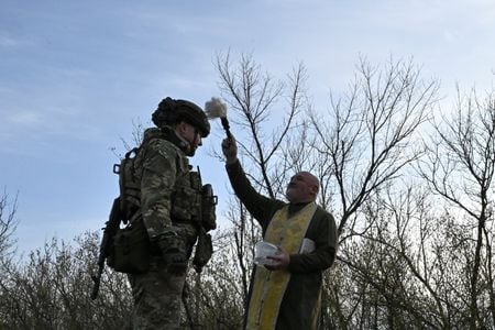 ウクライナ当局者は１０日、ロシアが１２日の正教会のイースター（復活祭）に合わせて発表した停戦について、期間を延長するとともに、戦争終結に向けた協議を再開するよう呼びかけた。ただ、ウクライナとロシアの双方で、今回の一時停戦が恒久的な和平につながることに懐疑的な見方が根強い。写真は４月８日、ウクライナ南部のザポリージャ州で正教会の復活祭を前にウクライナ兵に聖水をかける正教会の司祭（２０２６年　ロイター）