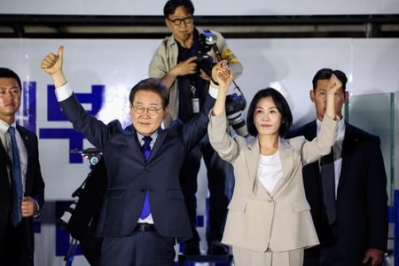 　６月３日投開票の韓国大統領選挙で勝利した革新系最大野党「共に民主党」の李在明前代表が４日、大統領に就任した。写真左は４日、ソウルの国会前で支持者にあいさつする李氏（２０２５年　ロイター/Kim Hong-Ji）