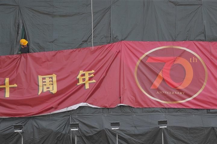 国慶節の祝典に向け、香港島中心部に中国建国70周年の横断幕を提げる労働者（9月30日、金鐘）　Susana Vera-REUTERS