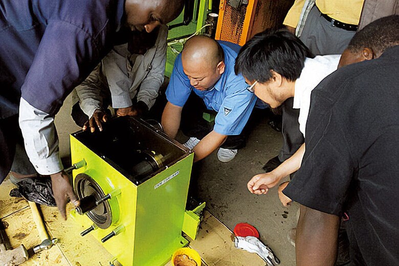 タンザニアでグラインドミルの使い方を指導する上杉（中央）　COURTESY OF TROMSO