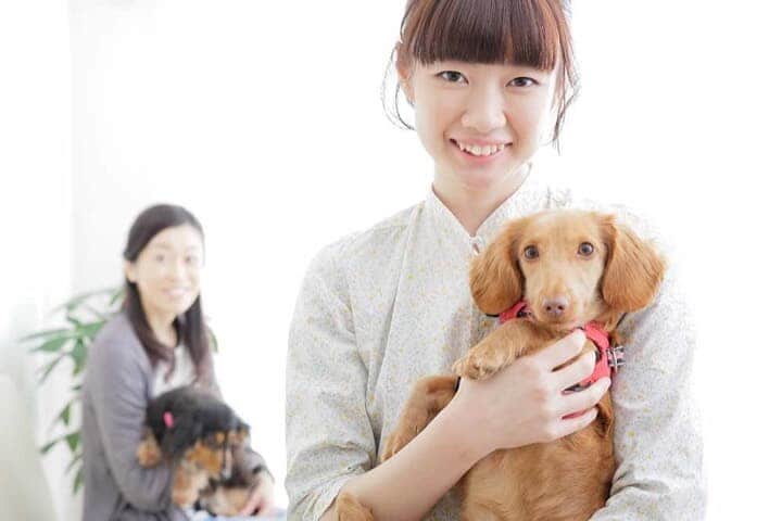 犬を抱く女性