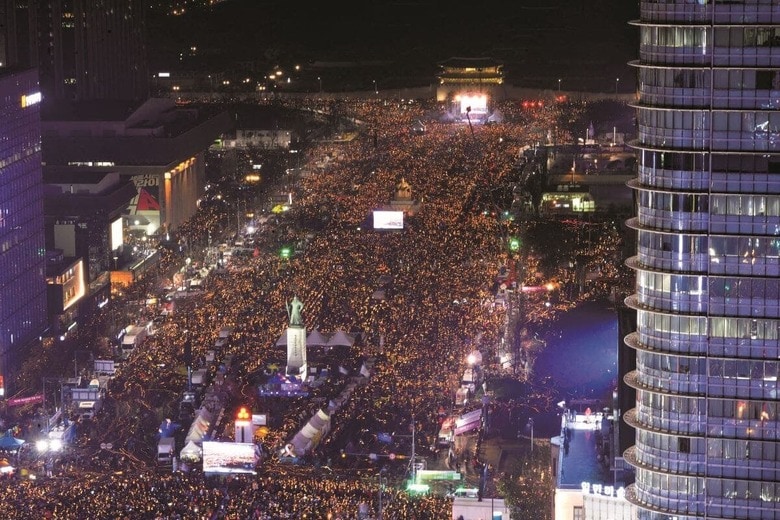 光化門広場の復活公演でBTSは新たな韓国像を世界に発信した（写真は2016年の「ろうそく革命」）　YONHAP NEWS/AFLO; ROBCARTORRES/SHUTTERSTOCK (GYEONGBOKGUNG ICONS)