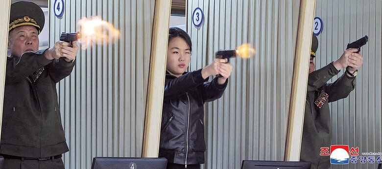 軍需工場で拳銃を試射するジュエ（中央）（26年3月）　KCNA-REUTERS