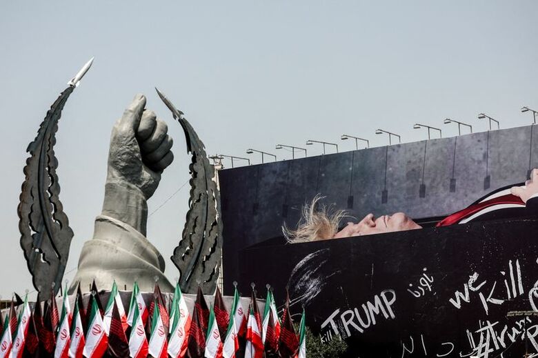 イランのテヘランで、故ハメネイ師の手を象徴する像の隣に、棺に横たわるトランプ米大統領を描いた看板が置かれている。7月23日撮影のWANA提供写真。REUTERS