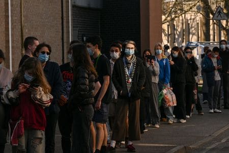 写真は3月18日、英ケント大学キャンパス内で髄膜炎のワクチン接種を受けるために並ぶ学生ら。REUTERS/Chris J. Ratcliffe
