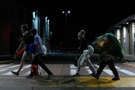 トランプ米政権は１０日、米国に不法滞在している移民が「自主的に出国」することを可能にする米税関・国境取締局（ＣＢＰ）のアプリ「ＣＢＰホーム」を立ち上げた。写真は９日、国外退去命令を受けた移民グループ。パナマ・パナマシティで撮影（２０２５年　ロイター/Enea Lebrun）