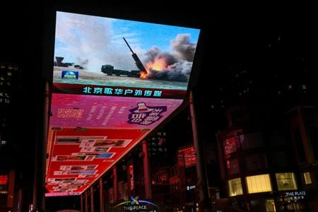 写真は2025年12月30日、中国・北京で、台湾周辺での軍事訓練に関する報道を映し出すスクリーン。REUTERS/Tingshu Wang/File Photo