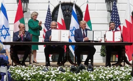 イスラエルのネタニヤフ首相（左から２番目）は１５日、米ワシントンのホワイトハウスで、アラブ首長国連邦（ＵＡＥ）とバーレーンとの国交正常化合意文書に署名した（２０２０年　ロイター/TOM BRENNER）