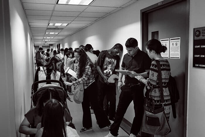 米ニューヨーク・マンハッタンのフェデラル・プラザにある移民裁判所の廊下で長い列を作る移民たち。滞在許可が得られることを祈り、審問を待つ