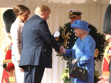　７月１３日、トランプ米大統領（中央）は、メラニア夫人と共にロンドン郊外のウィンザー城でエリザベス女王（右）と面会した。代表撮影（２０１８年　ロイター）