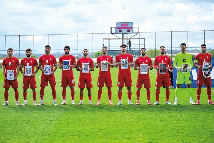 イラン代表は3月31日の親善試合前のセレモニーで、戦争の犠牲となった子供らの写真を手にした