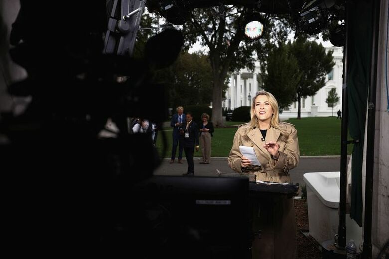 米ホワイトハウス前で取材を行うＣＮＮの記者。２４日撮影。REUTERS/Kevin Lamarque