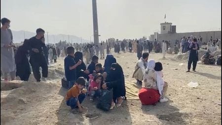 　８月１８日、米国のオースティン国防長官は、イスラム主義組織タリバンが全権掌握したアフガニスタンについて、米軍は現在、首都カブールの空港の安全確保に専念しているため、退避しようとしている人々を市内から空港に移動させる手助けはできていないと述べた。写真はカブールの空港の外で、銃声が聞こえた後安全を確保しようとする人々。１８日撮影（２０２１年　ロイター/ASVAKA NEWS）