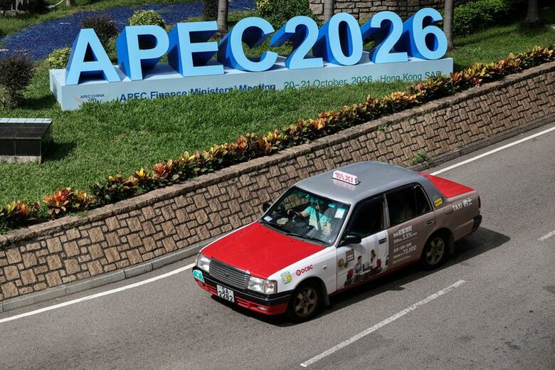 写真はＡＰＥＣ2026の看板の前を通り過ぎるタクシー。10月20日、中国・香港で撮影。REUTERS/Tyrone Siu