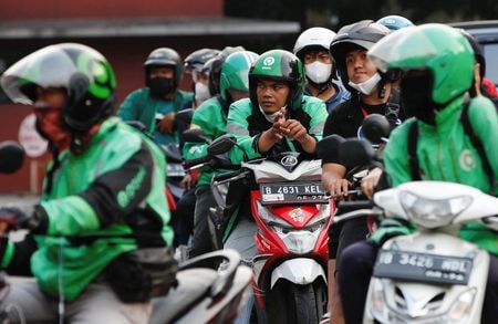 ８月２６日、    インドネシア政府は補助金付き燃料を３０─４０％値上げする可能性がある。写真は２２日、ジャカルタのガソリンスタンドに並ぶバイクの人々（２０２２年　ロイター/Ajeng Dinar Ulfiana）