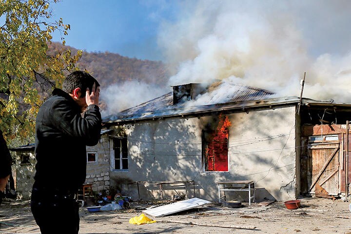 アゼルバイジャンの支配下に入る日を前に、ナゴルノカラバフから脱出する住民が火を放った民家　REUTERS