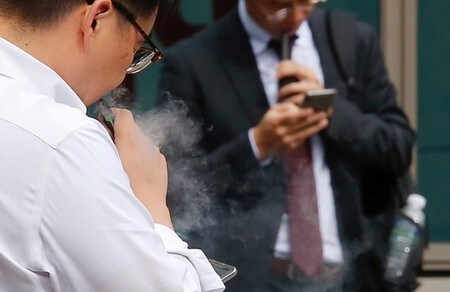 　１０月２３日、韓国の朴凌厚・保健福祉相は、電子たばこに対する健康懸念の高まり受け、国民に液体式電子たばこの使用をやめるよう勧告した。写真はソウルで電子たばこを吸う男性（２０１９年　ロイター/Heo Ran）