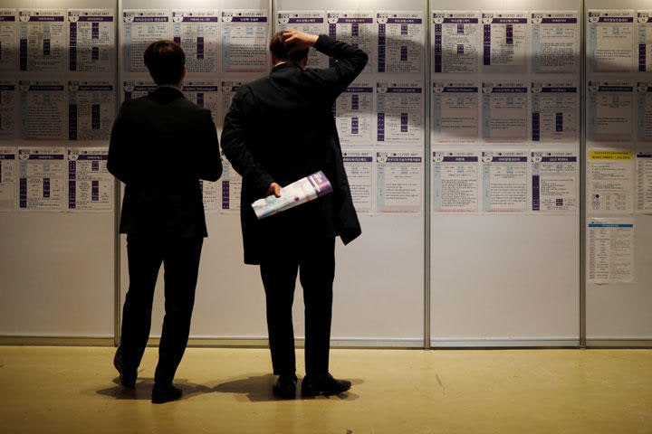 求人情報を眺める男性2人（2017年4月12日、ソウルで開催された求職イベントにて）　Kim Hong-Ji-REUTERS