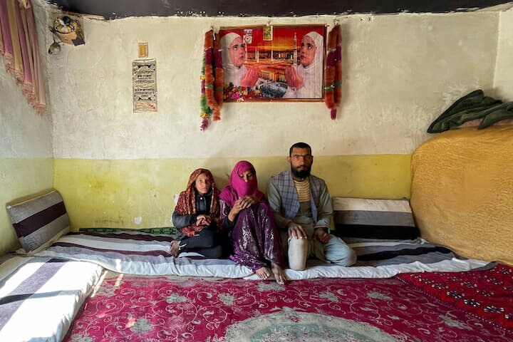 アフガニスタン・カブールで、地雷で両足を失った男性の家族　REUTERS/Sayed Hassib