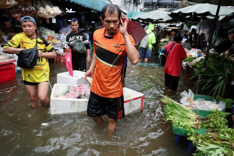 9月28日、浸水したバンコクの市場を歩く人々。 REUTERS/Athit Perawongmetha