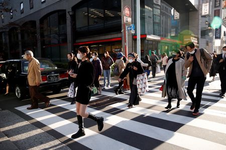 政府は２１日に発表した１２月の月例経済報告で、景気判断を示す総括判断を１年５カ月ぶりに上方修正した。新型コロナウイルスによる影響緩和で個人消費が改善しているのが主な理由。項目別では「個人消費」と「業況判断」、「雇用情勢」を上方修正、「設備投資」と「住宅建設」を下方修正した。写真は都内で１１月撮影（２０２１年　ロイター／Androniki Christodoulou）