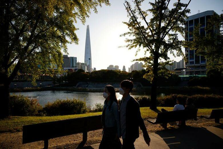 韓国疾病予防管理庁(KDCA)の13日発表によると、前日確認された新型コロナウイルス感染者数が6日ぶりに100人を超えた。写真はソウル市内の公園をマスク姿で歩く人たち。10月9日撮影。(2020年　ロイター/Kim Hong-Ji)