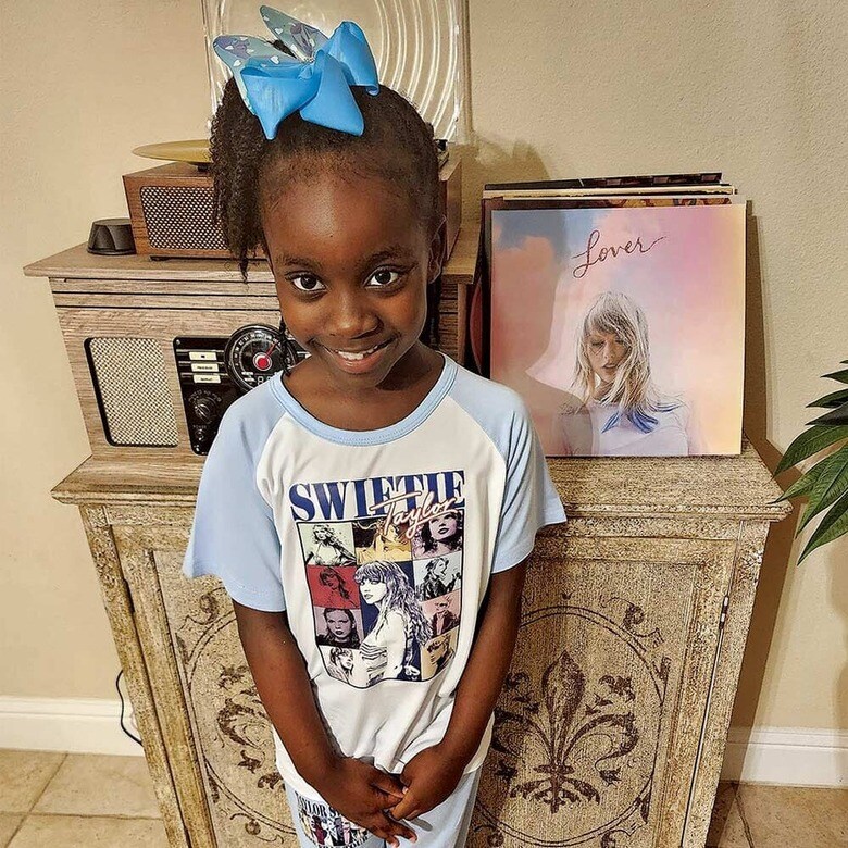 「スウィフティー」のTシャツを着てテイラーのレコードの横に立つアマヤ　EMERI MONTGOMERY