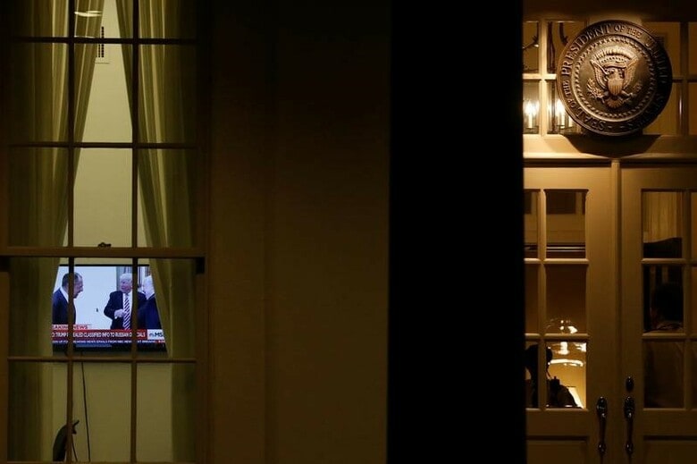 ５月１５日、ロイター／イプソスが公表した世論調査によると、２０１６年の米大統領選を巡り、米国人の大半がトランプ大統領とロシアのつながりを探るための「独立した調査」を望むと回答した。写真はラブロフ・ロシア外務大臣・在米ロシア大使とトランプ米大統領の会見報道のニュースが流れるテレビ。米ワシントン・ホワイトハウスで撮影（２０１７年　ロイター／Jonathan Ernst）