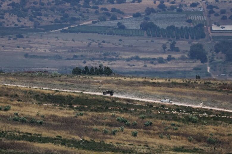 6月10日、国境のイスラエル側から見える、レバノン南部を走行するイスラエル軍の車両。 REUTERS/Ammar Awad