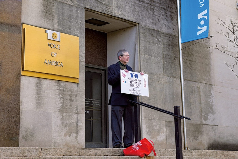 トランプが縮小を決定したVOAの本部前で、トランプの決定に抗議する男性　ANDREW LEYDENｰNURPHOTOｰREUTERS