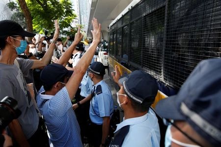 　５月２０日、香港の高等裁判所は２０日、香港国家安全維持法（国安法）に違反したとして初めて起訴された唐英傑被告（２４）について、陪審なしで審理すると決めた。写真は香港の裁判所の外で、唐英傑被告が乗った車両に集まる支持者ら。２０２０年７月撮影（２０２１年　ロイター/Tyrone Siu）