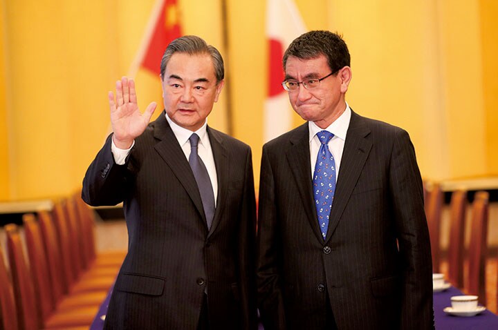 中国・王毅外相（左）の言葉を聴く日本の河野外相　REUTERS