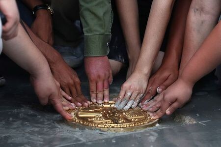 　抗議デモが続くタイでは週末も大規模なデモが実施され、２０日には「この国は国民のもので国王のものでない」などと刻まれたプレートをデモ隊が王宮前広場に埋め込んだ。だがプレートはその後、何者かによりはがされたことが明らかになった。写真はプレートを埋める学生ら（２０２０年　ロイター／Athit Perawongmetha）