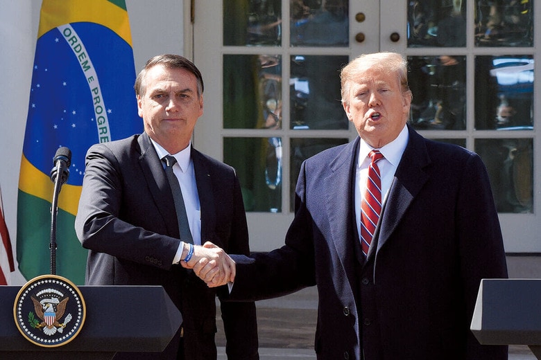 ホワイトハウスでトランプと握手するボルソナロ（左、2019年）　OLIVIER DOULIERYｰABACAPRESSｰREUTERS
