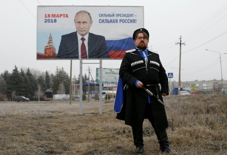 ３月１２日、１８日に行われるロシア大統領選でプーチン氏に票を投じようと考えているロシア人の大半は、信頼の根底にあるのは「安定」だと語る。写真はプーチン氏支持者の男性。ミハイロフスクで２月撮影（２０１８年　ロイター/Eduard Korniyenko）