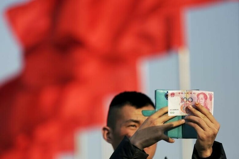 ３月２３日、中国の通貨、人民元の相場は２０１６年に入って徐々に下落しているが、この事実はあまり気付かれていない。写真は北京で２日撮影(２０１６年　ロイター／Damir Sagolj)