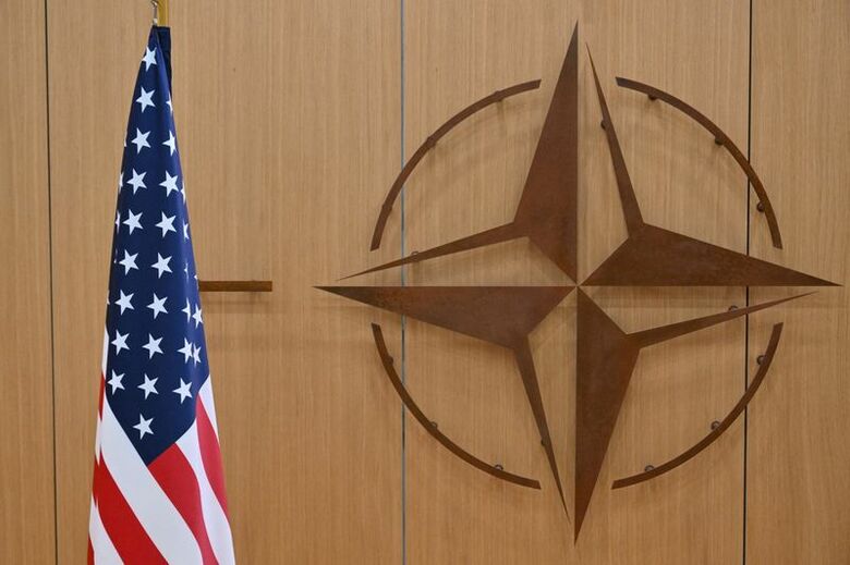 写真はＮＡＴＯのロゴと米国旗。２０２５年２月、代表撮影。REUTERS