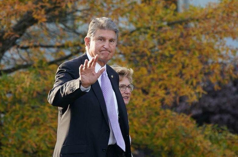 米民主党穏健派のジョー・マンチン上院議員は、気候変動・社会保障関連歳出法案「ビルド・バック・ベター（よりよき再建）」について、ホワイトハウスのスタッフが「容認しがたい」ことを行ったため不支持を表明するに至ったと述べた。 写真は11月18日、ホワイトハウスの外を歩きながら記者団に手を振るマンチン議員（2021年　ロイター／Kevin Lamarque）