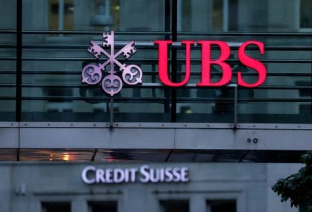 スイスの金融大手ＵＢＳは、救済買収した同業クレディ・スイスの香港を拠点とする証券リサーチ部門スタッフの約７０％を削減した。事業統合の一環。関係筋が明らかにした。写真は８月撮影のクレディ・スイスとUBSのロゴ（２０２３年　ロイター／Denis Balibouse）