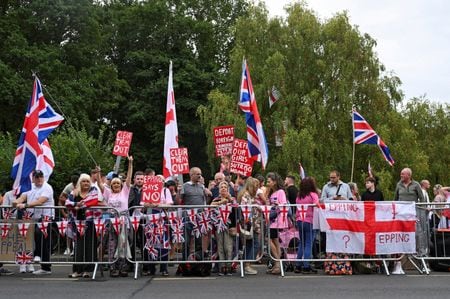 　８月２４日、英国各地で、難民認定申請者を受け入れているホテルの外で移民に反対するデモが続いた。写真は、ロンドンで高等法院が下した亡命希望者収容の仮差し止め命令を受け、ベル・ホテル前で反移民デモを行う人たち。英エッピングで２４日撮影（２０２５年　ロイター/Jaimi Joy）