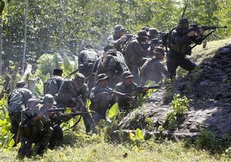 ５月１４日、フィリピンのパラワン島にあるウルガン湾周辺の住民はかつて、湾の奥に位置する海軍基地の増強に反対していたが、「中国脅威論」を背景に今では賛成が大勢だという。写真は４月、ウルガン湾で合同演習するフィリピン軍と米軍の兵士（２０１５年　ロイター/Romeo Ranoco）