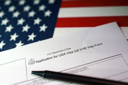 　９月２３日、トランプ米政権は、高度な外国人技術者向けの就労ビザ（査証）「Ｈ―１Ｂ」の選考方法を変え、所得と技能が高い人ほど有利な仕組みにする案を発表した。写真は米国旗とビザ申請書を組み合わせたイメージ。９月２２日、ボスニア・ヘルツェゴビナのゼニカ市で撮影（２０２５年　ロイター/Dado Ruvic）