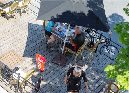 　９月２８日、カナダで人口の最も多い２州を中心に、新型コロナウイルスの新規感染者が再び急増している。写真はケベック州モントリオールで６月２２日、レストランのパティオで食事をする人々（２０２０年　ロイター/Christinne Muschi）