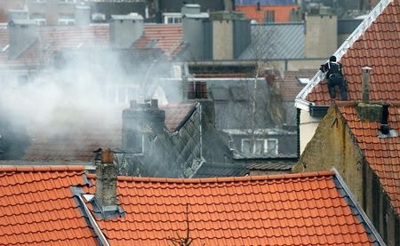 　３月１５日、ベルギーの首都ブリュッセルで、昨年１１月のパリ同時多発攻撃の関連捜査をしていた警官らが発砲を受け、４人が負傷した。屋根から現場を監視するベルギーの警官（２０１６年　ロイター／Yves Herman）