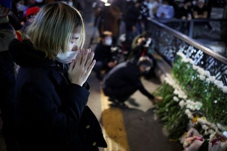韓国の韓悳洙首相は３１日、首都ソウルの繁華街、梨泰院で２９日夜に起きた雑踏事故を受けて、原因を徹底的に調査すると述べた。写真は現場付近で手を合わせる女性、３０日撮影（２０２２年　ロイター／Kim Hong-ji）