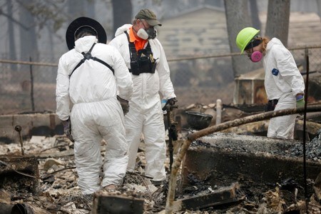 １１月１５日、米カリフォルニア州で発生した大規模な山火事で、地元当局は、行方不明者が６３０人に達したと明らかにした。焼け落ちた住宅で捜索活動をする人類学者ら。カリフォルニア州パラダイスで１４日撮影（２０１８年　ロイター／TERRAY SYLVESTER）
