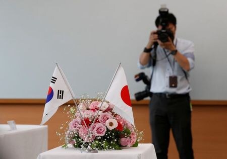 １２月２０日、経済産業省は、韓国向け輸出管理を厳格化していた半導体材料３品目のうち、感光剤「レジスト」について、措置の見直しを行った。写真は日韓の国旗。東京で７月撮影（２０１９年　ロイター/Kim Kyung-Hoon）